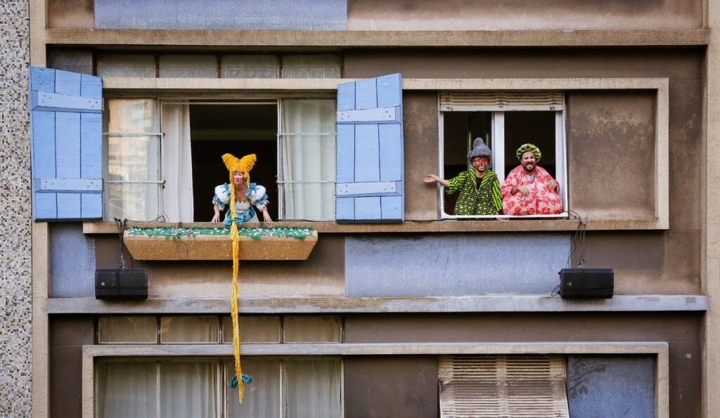 Atores caracterizados nas janelas do Teatro de Janela, no Minhocão